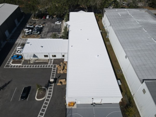 Aerial view of a commercial rubber roof restored with a reflective white coating in Florida